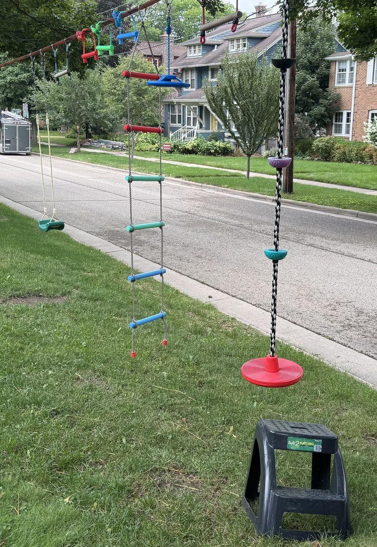 A homemade ninja warrior course strung between trees in a front yard