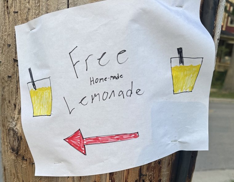 A hand-drawn sign reading Free Home-made Lemonade with an arrow